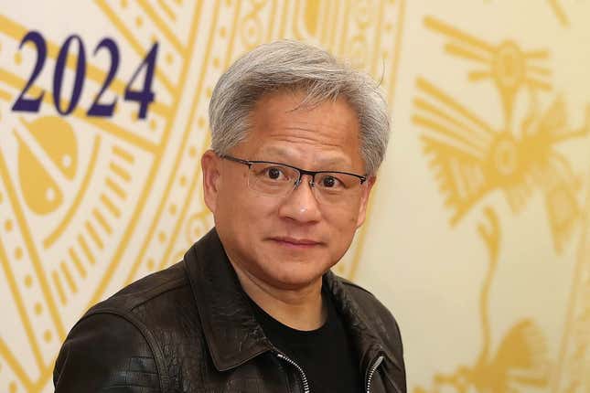 Jensen Huang with a serious look on his face wearing glasses in front of a yellow backdrop that has yellow drawings and 2024 written in navy