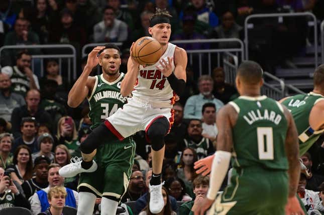 Oct 30, 2023; Milwaukee, Wisconsin, USA;  Miami Heat guard Tyler Herro (14) grabs a rebound against Milwaukee Bucks forward Giannis Antetokounmpo (34) in the first quarter at Fiserv Forum.