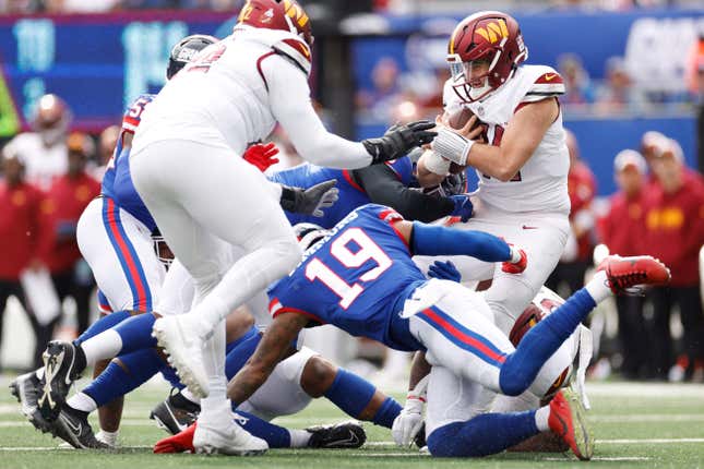 EAST RUTHERFORD, NEW JERSEY - OCTOBER 22: Dexter Lawrence II #97 and Kayvon Thibodeaux #5 of the New York Giants sack Sam Howell #14 of the Washington Commanders in the second quarter of the game at MetLife Stadium on October 22, 2023 in East Rutherford, New Jersey. (Photo by Sarah Stier/Getty Images)