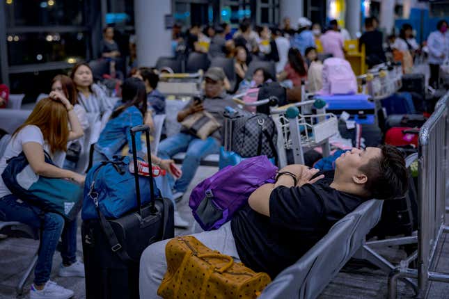 Passengers wait for check-in counters to open at Ninoy Aquino International Airport, amid a global IT disruption caused by a Microsoft outage and a Crowdstrike IT problem, on July 19, 2024 in Manila, Philippines