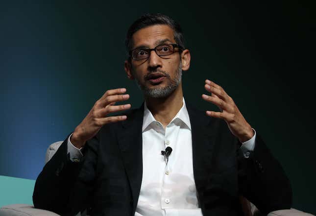 Sundar Pichai speaking with his hands up, he's looking out onto an audience