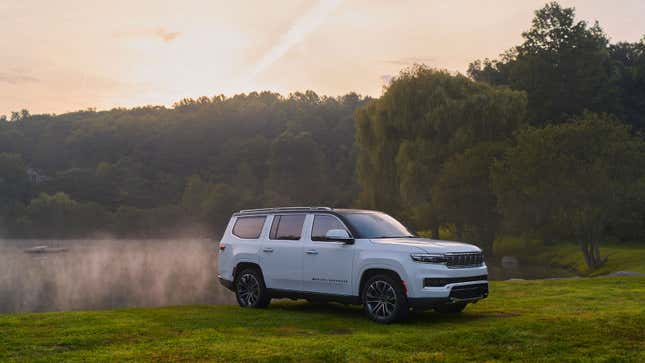 A photo of a white Grand Wagoneer SUV in a field. 