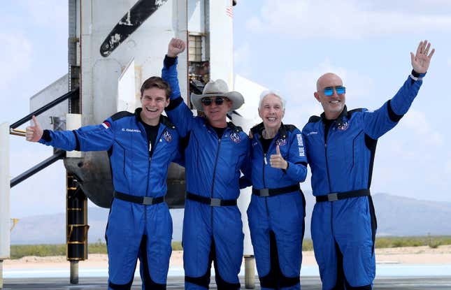 L’équipage du New Shepard de Blue Origin (de gauche à droite) Oliver Daemen, Jeff Bezos, Wally Funk et Mark Bezos posent pour une photo près du propulseur après avoir volé dans l’espace à bord de la fusée New Shepard de Blue Origin le 20 juillet 2021 à Van Horn, au Texas.