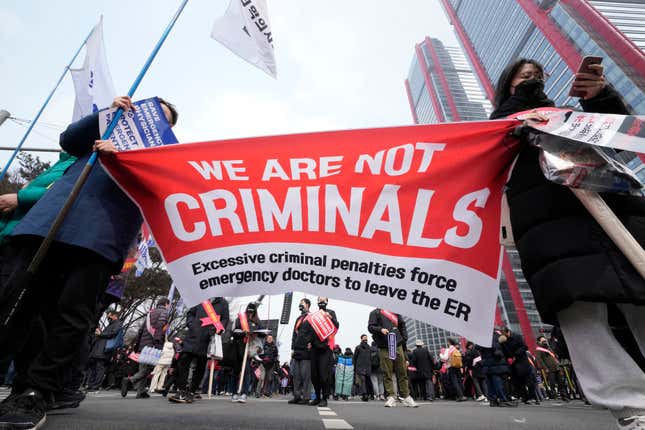 Doctors hold a banner during a rally against the government&#39;s medical policy in Seoul, South Korea, Sunday, March 3, 2024. Thousands of senior doctors rallied in Seoul on Sunday to express their support for junior doctors who have been on strike for nearly two weeks over a government plan to sharply increase the number of medical school admissions. (AP Photo/Ahn Young-joon)