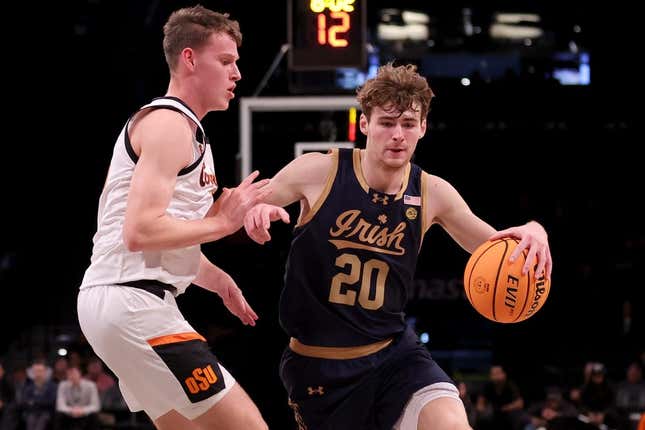 Nov 17, 2023; Brookyln, NY, USA; Notre Dame Fighting Irish guard J.R. Konieczny (20) controls the ball against Oklahoma State Cowboys guard Connor Dow (13) during the first half at Barclays Center.
