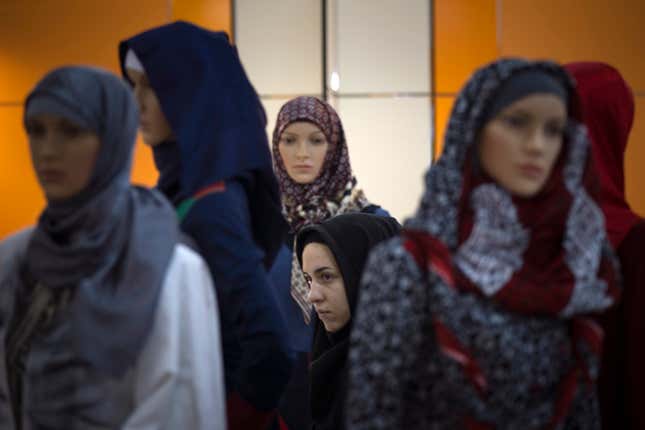 A woman walks past mannequins covered with Islamic clothing designed by Iranian designers while visiting an Islamic fashion exhibition in central Tehran March 1, 2012.