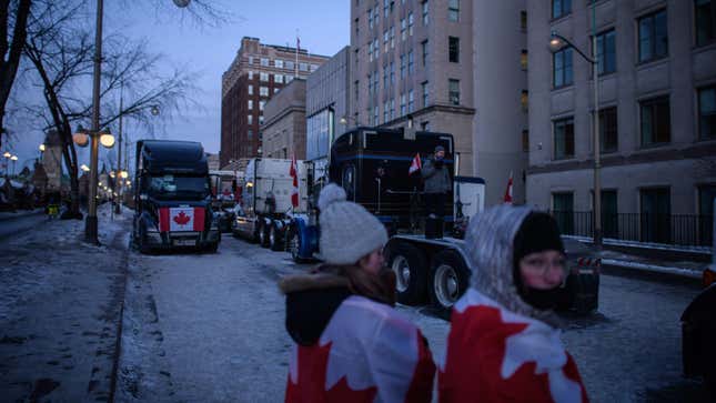 Demonstrators stand before trucks during a protest by truck drivers over pandemic health rules and the Trudeau government, outside the parliament of Canada in Ottawa on February 13, 2022. 
