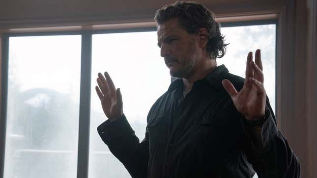 Joel raises his hands while looking at something off-screen.
