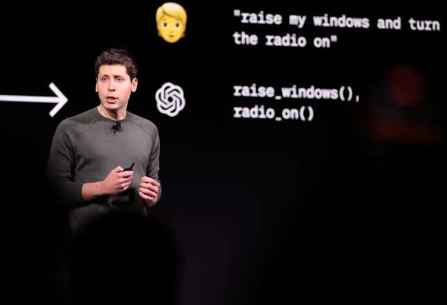 Sam Altman speaking with a display of ChatGPT behind him