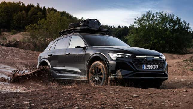 Front 3/4 view of a black Audi Q8 E-Tron driving through mud