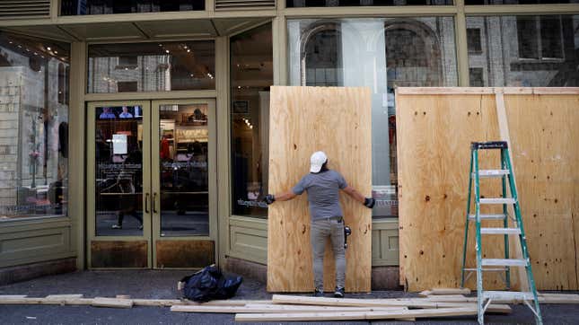 A worker removes boarding from a Vineyard Vines store following protests against the death in Minneapolis police custody of George Floyd.