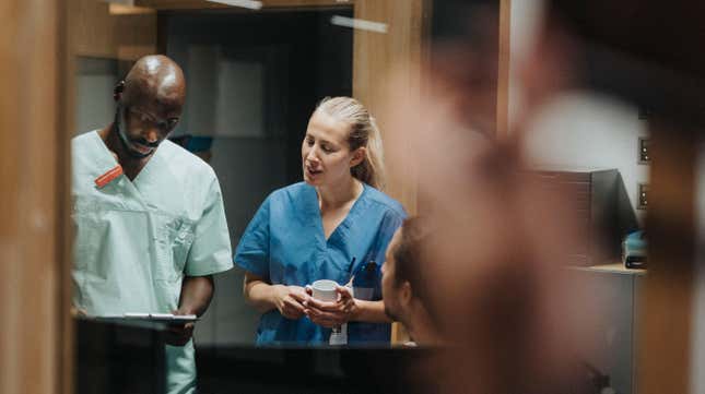 Une travailleuse de la santé discutant avec du personnel médical masculin à l’hôpital