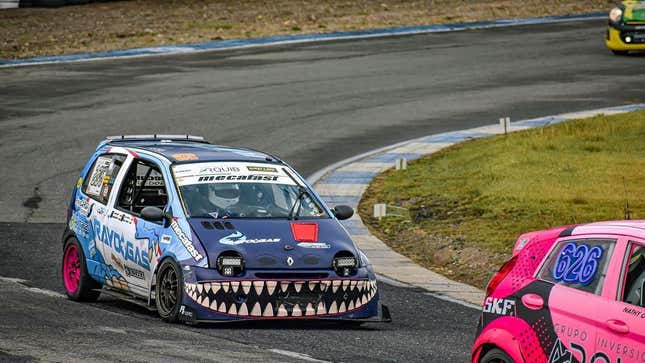 A photo of a heavily modified Twingo on a race track with a giant shark tooth mouth looking properly menacing