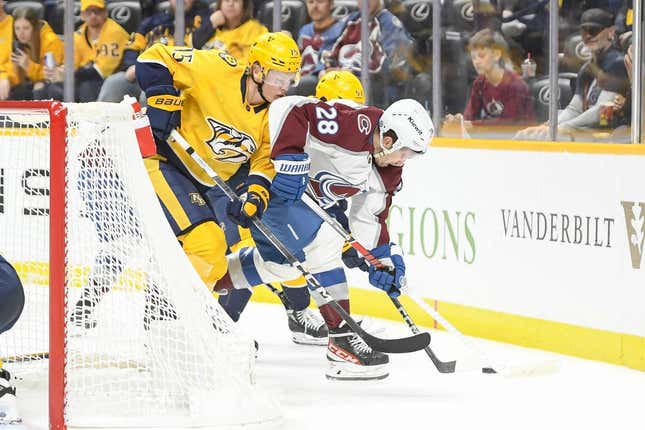 Nov 20, 2023; Nashville, Tennessee, USA;  Nashville Predators center Juuso Parssinen (75) and Colorado Avalanche left wing Miles Wood (28) fight for the puck during the second period at Bridgestone Arena.