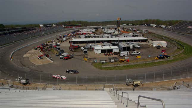 A photo of Wilkesboro race track with stock cars driving round. 