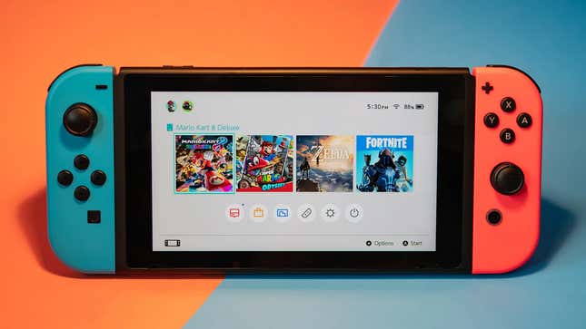 A Nintendo Switch sits in front of an orange and blue background.