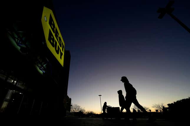 FILE - People are silhouetted against the sky at dawn as they attend a sale at a Best Buy store Friday, Nov. 25, 2022, in Overland Park, Kan. Best Buy reported lower fourth-quarter sales and net income, Thursday, Feb. 29, 2024, as shoppers remain cautious about spending on gadgets. (AP Photo/Charlie Riedel, File)