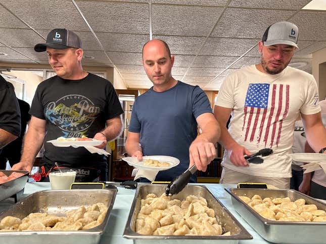 FILE - Maksym Bunchukov, Andrii Hryshchuk and Ivan Sakivskyi help themselves to perogies at a lunch hosted Monday, July 17, 2023, by the Ukrainian Cultural Institute in Dickinson, North Dakota. The North Dakota Petroleum Council&#39;s Bakken Global Recruitment of Oilfield Workers program placed about 60 Ukrainians with 16 employers throughout western North Dakota from July to November 2023, Council President Ron Ness said. The group shelved the program due to lack of demand from companies, he said. (AP Photo/Jack Dura, File)