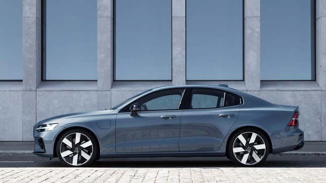 A gray Volvo S60 sedan parked in front of a building from the side angle