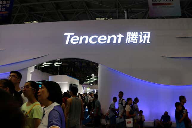 signe de Tencent en lettres blanches sur un mur au-dessus de beaucoup de gens