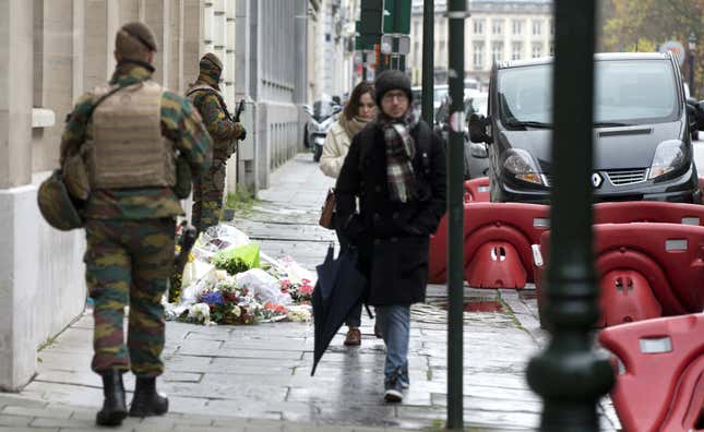 Belgian Army soldiers patrol next to flowers left outside of the French Consulates office in Brussels Saturday, Nov. 21, 2015. Belgium raised it security level to it's highest degree on Saturday as the manhunt continues for extremist Salah Abdeslam who took part in the Paris attacks.