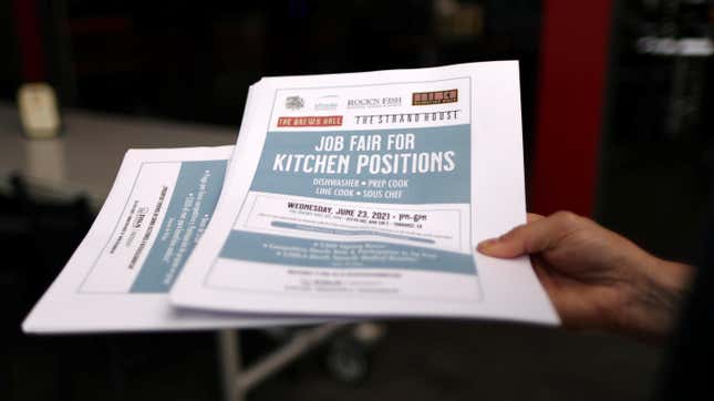 A woman holds fliers for a job fair for restaurant and hotel workers, after coronavirus disease (COVID-19) restrictions were lifted, in Torrance, near Los Angeles, California, U.S., June 23, 2021.