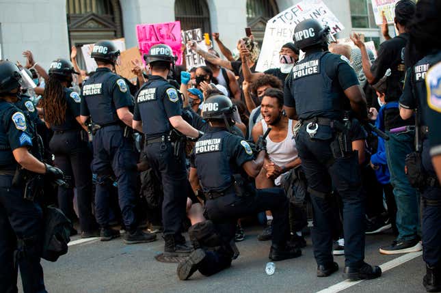 A man screams with emotion as he sees a policeman take a knee while hundreds protest the death of George Floyd next to the White House on May 31, 2020 in Washington, DC.