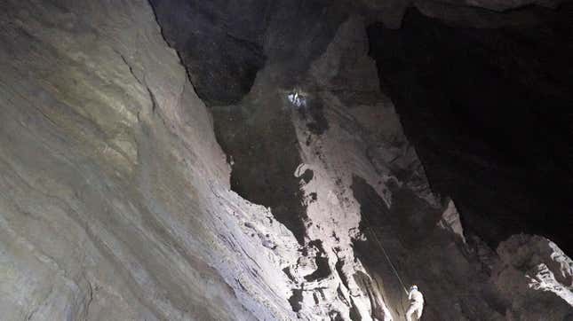 An explorer descends through one of the cave chambers.