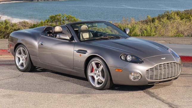 A front 3/4 shot of the gray Aston DBAR1 parked in front of the ocean