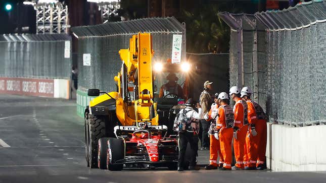 A photo of crews recovering Carlos Sainz's Ferrari F1 car. 