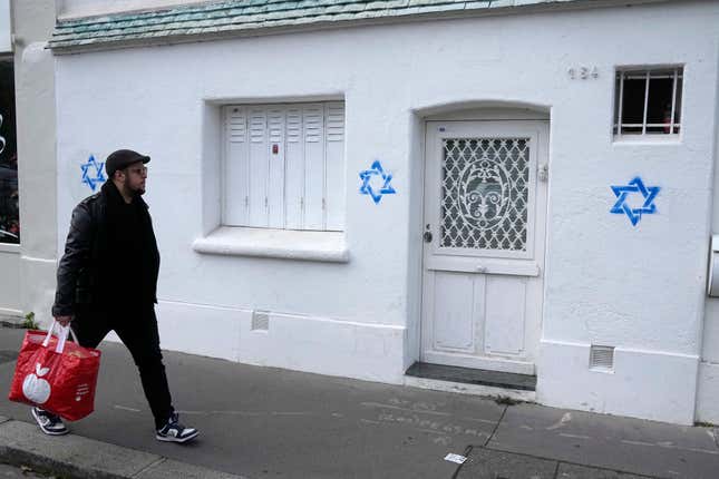 FILE - A man walks by Stars of David tagged on a wall on Oct. 31, 2023 in Paris. France says it has been the target of a Russian online destabilization campaign that used bots to whip up controversy and confusion about spray-painted Stars of David that appeared on Paris streets. (AP Photo/Michel Euler, Pool)