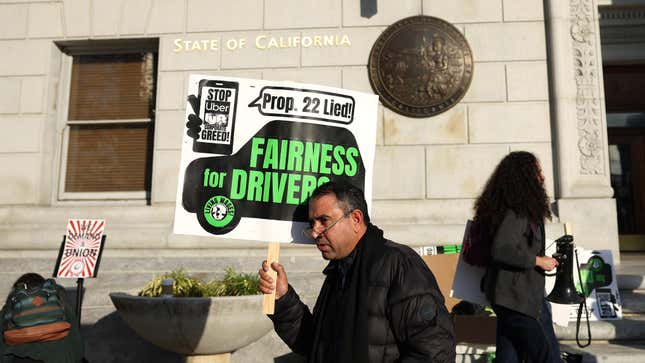 A gig worker with the California Gig Workers Union holds a sign during a rally against Proposition 22 outside of the California First Appellate District Court of Appeal on December 13, 2022 in San Francisco, California.