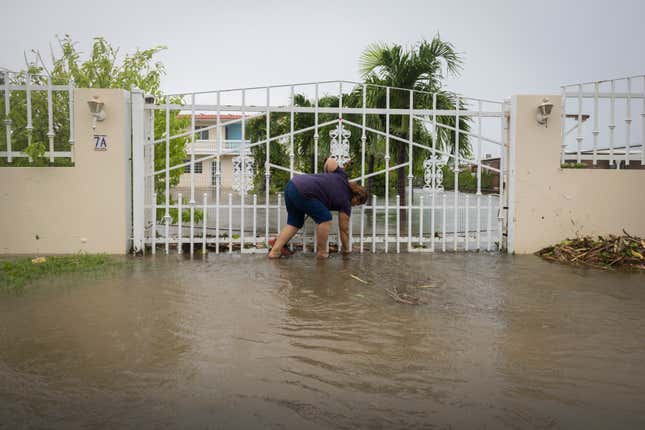 Photo of woman bending over in floodwaters