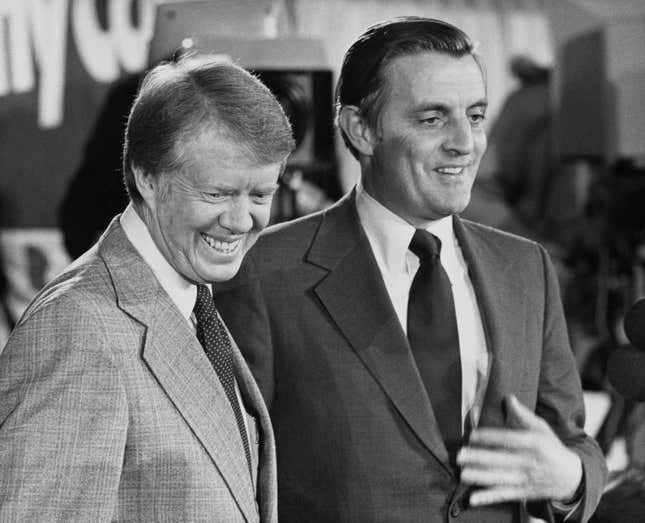 Der amerikanische Politiker und gewählte Präsident Jimmy Carter und der amerikanische Politiker und gewählte Vizepräsident Walter Mondale (1928–2021) lächeln alle, als sie am 4. November 1976 an einer Pressekonferenz nach den Wahlen in Plains, Georgia, teilnehmen. 