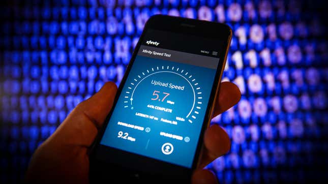 An internet speed test website is seen on a mobile device with teh logo for Xfiniity surrounded by 1s and 0s representing data.