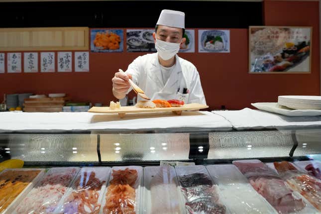 FILE - A sushi chef prepares a plate at the Toyosu Market Monday, Jan. 29, 2024, in Tokyo. Japan&#39;s economy managed to grow in the fourth quarter of last year, averting a recession, according to revised government data released Monday, March 11, 2024 that had previously shown a contraction. (AP Photo/Eugene Hoshiko, File)