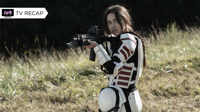Rosita, clad in white Commonwealth armor, aims her assault rifle while standing in a field.
