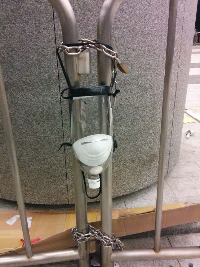 A gas mask made out of a plastic bottle hangs at a protest site in Admiralty.