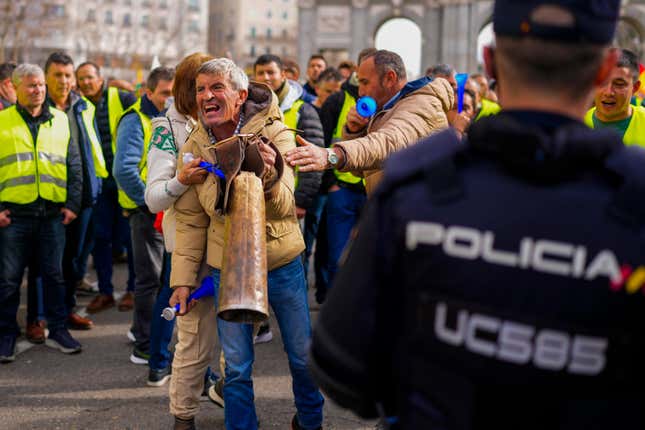 A farmer shakes a cowbell during a protest in Madrid, Spain, Wednesday, Jan. 21, 2024. Hundreds of farmers drove their tractors into central Madrid on Wednesday as part of ongoing protests against European Union and local farming policies and to demand measures to alleviate production cost hikes. (AP Photo/Manu Fernandez)