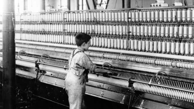 1909'da İngiltere'de iplik yapma makinesini çalıştıran genç bir çocuk.