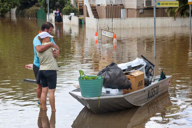 People hug after moving their belongings to a boat from a flooded home at Torwood Street, Auchenflower in Brisbane, Australia. March 3, 2022