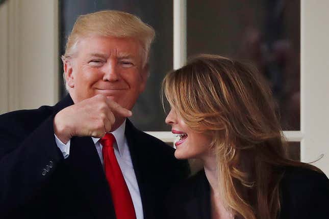 U.S. President Donald Trump reacts as he stands next to former White House Communications Director Hope Hicks.
