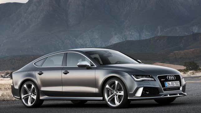 A dark grey Audi RS7 from the front 3/4 parked in front of mountains