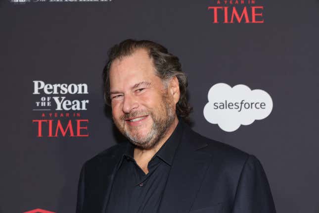 Marc Benioff smiling in front of a backdrop that says Person of the Year, A Year in Time and has a white cloud with the Salesforce logo