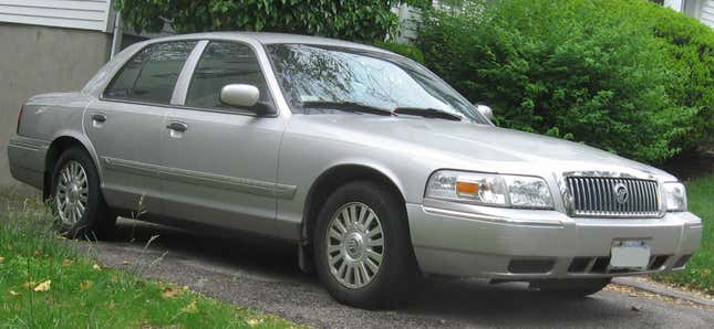 Un Grand Marquis plateado 2008 estacionado en un  camino de entrada