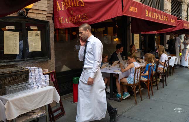 A waiter walks among tables at a New York City restaurant.