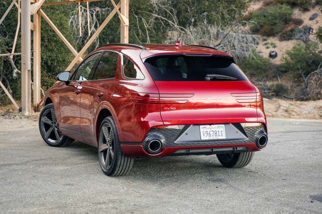 The rear of a Genesis GV70 in red.