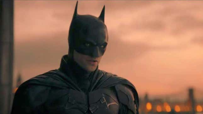 Batman berdiri di atas gedung saat matahari terbit