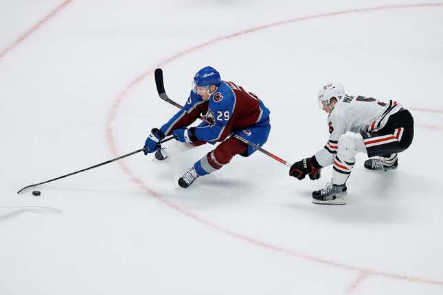 Oct 19, 2023; Denver, Colorado, USA; Colorado Avalanche center Nathan MacKinnon (29) controls the puck under pressure from Chicago Blackhawks defenseman Connor Murphy (5) in the third period at Ball Arena.