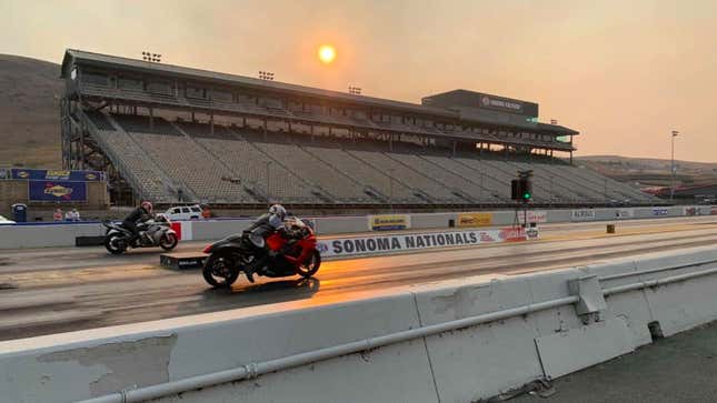 A photo of two motorbikes lined up at a drag strip. 